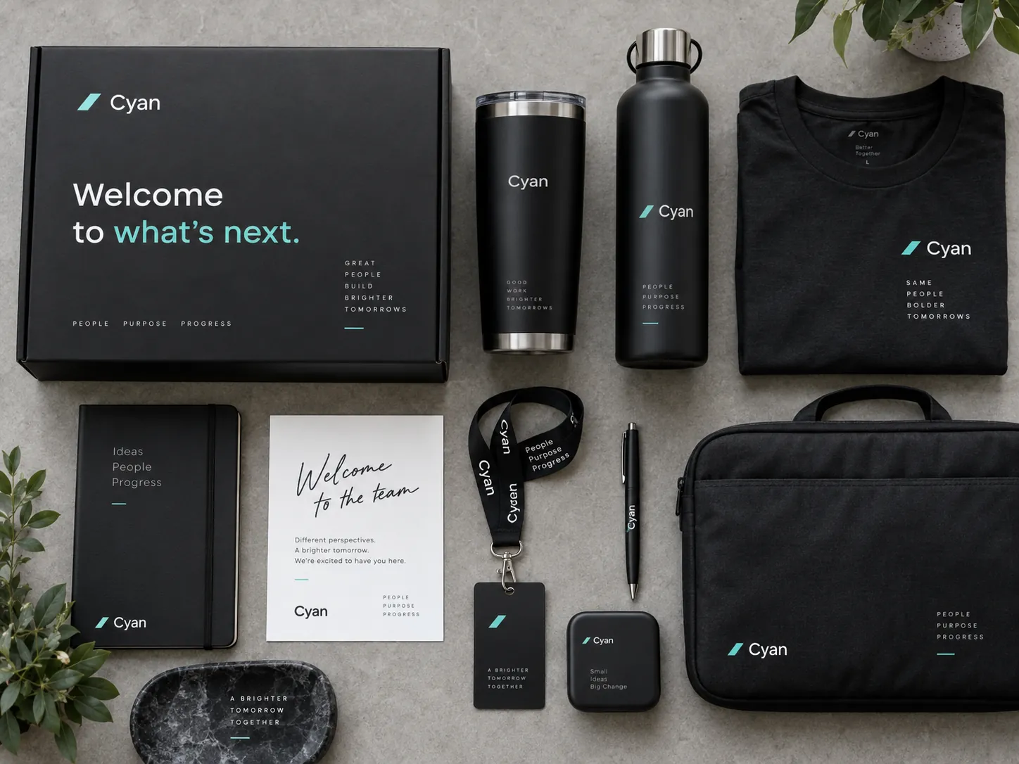 Flat lay of welcome pack contents: notebook, pen, bottle, T-shirt, lanyard and welcome card