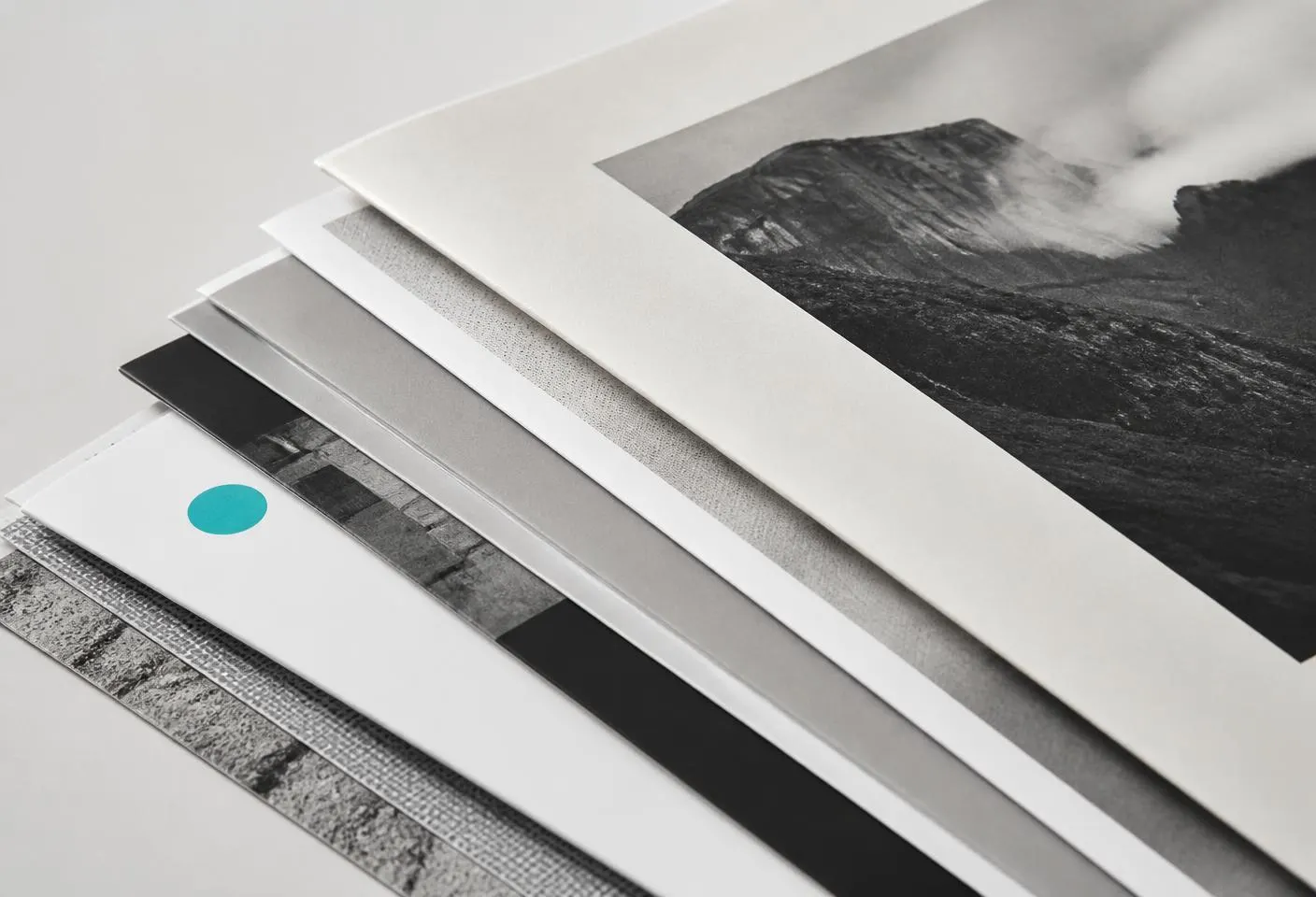 Freshly printed press sheets and brochures fanned in a stack during production.